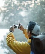 Person in Yellow Jacket Taking Photo in the Forest