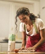 Happy woman with rolling pin cooking at home